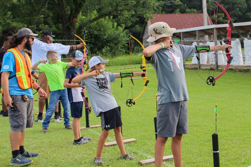 group shooting bows and arrows