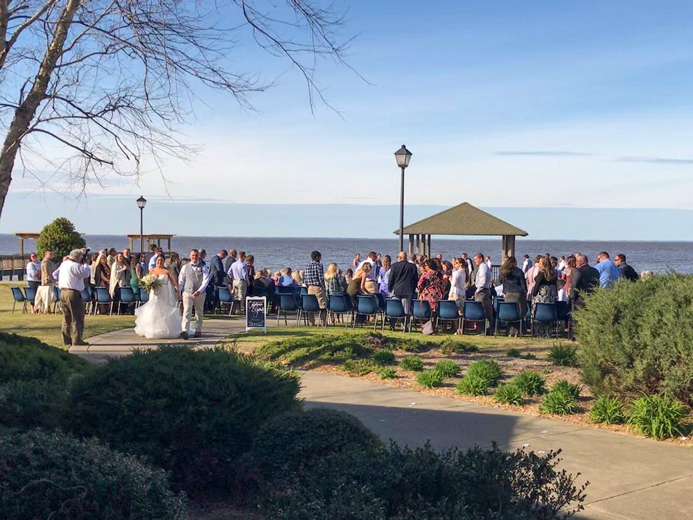 couple walking down aisle at waterfront wedding